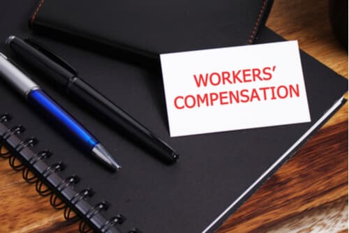 workers' compensation on top of a notepad
