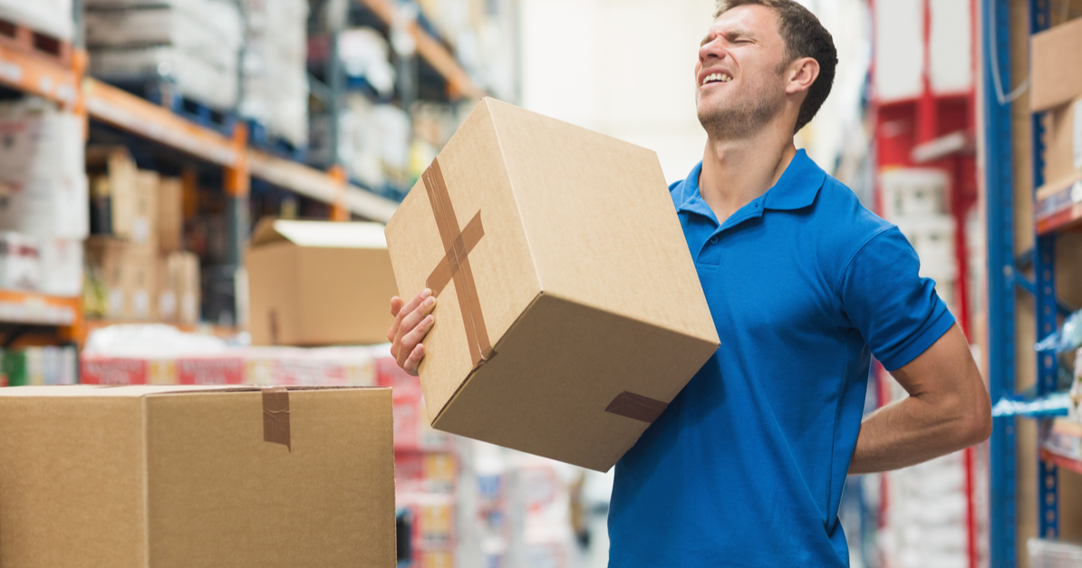 Man suffering from overexertion injury for lifting heavy boxes